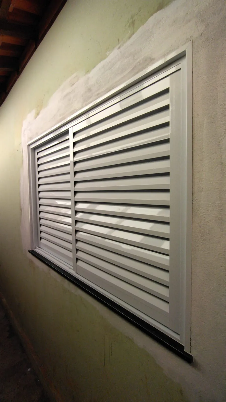 Janela de alumínio branco tipo veneziana recém-instalada