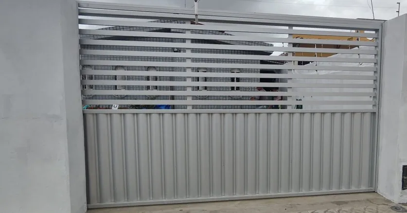 Portão de alumínio cinza com lambril na base e palhetas horizontais
